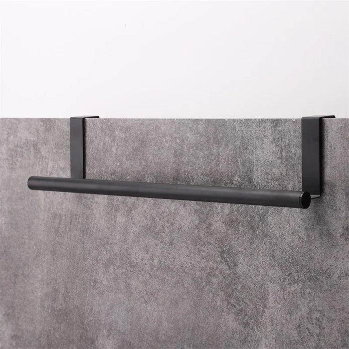 Stainless steel towel bar hanging behind cabinet door with rubber pad