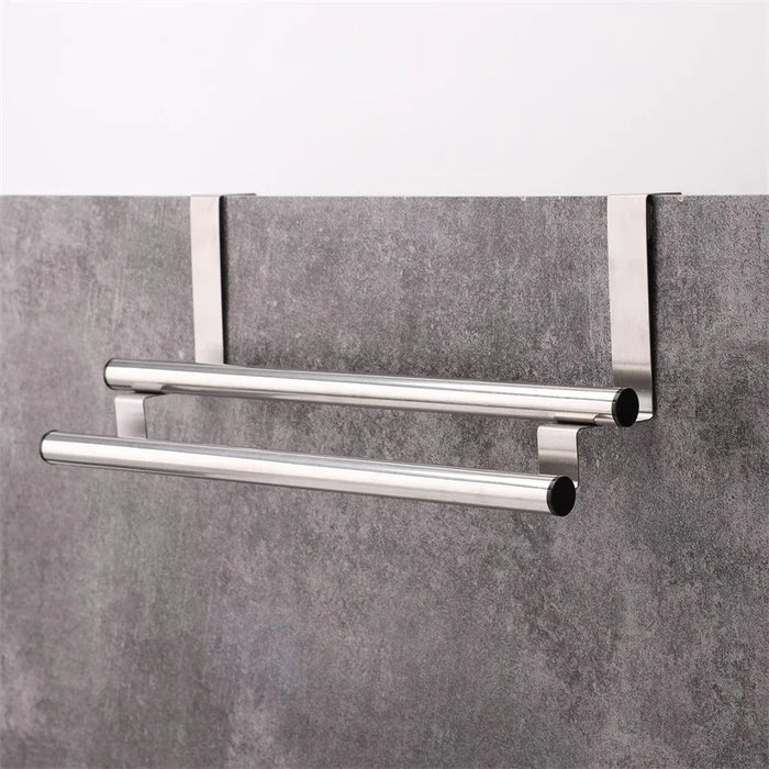 Stainless steel towel bar hanging behind cabinet door with rubber pad